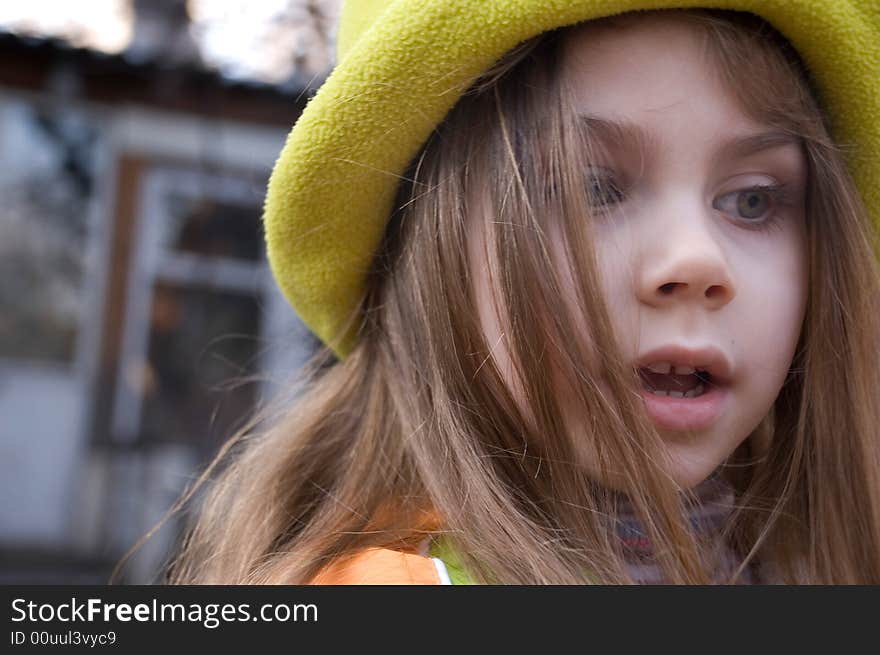 Little pretty thoughtful girl wearing a green hat. Little pretty thoughtful girl wearing a green hat