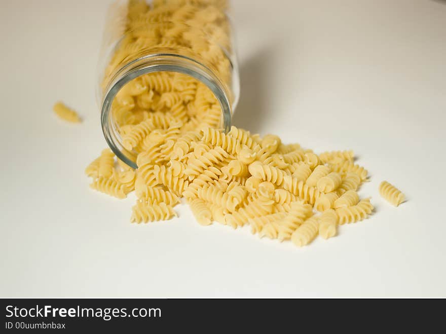 Italian fusilli pasta falling out of a glass jar