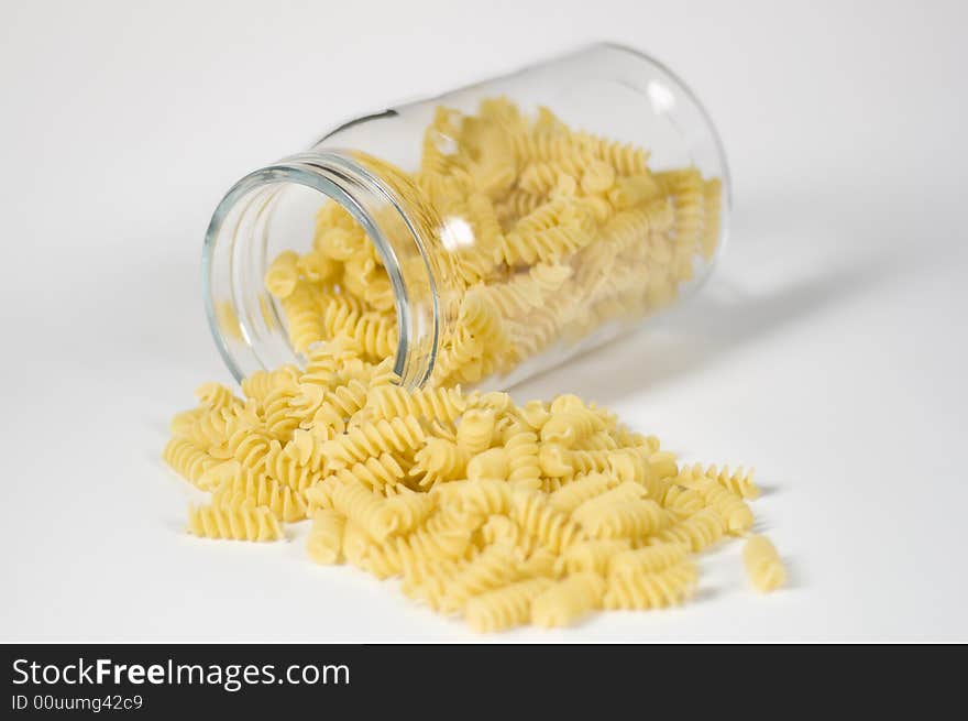 Italian fusilli pasta falling out of a glass jar