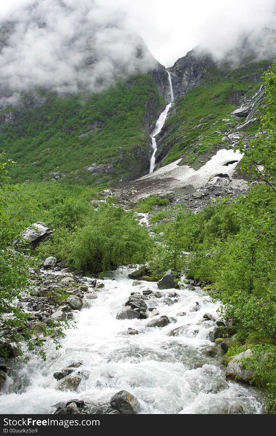 Raging river among the rocks, waterfall, fog, cloudy