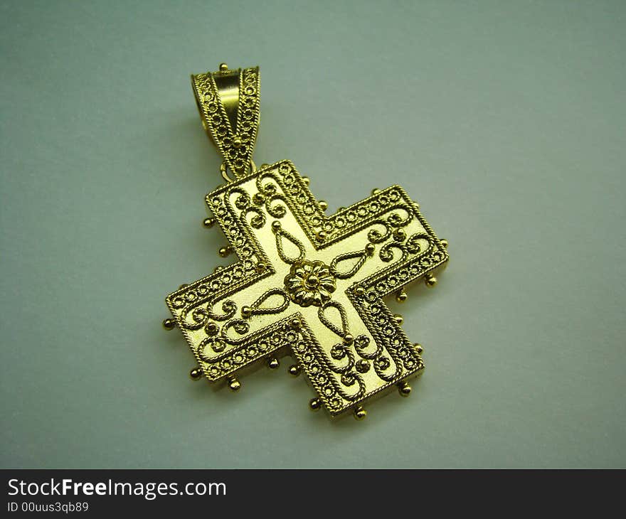 Antique golden cross jewel for necklace lying on paper