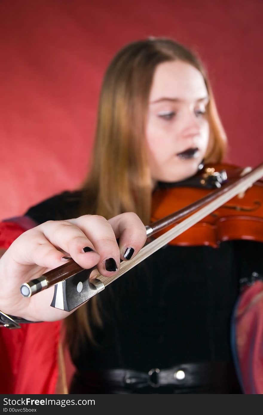 The young woman with gothic cosmetics plays on a violin. The young woman with gothic cosmetics plays on a violin.