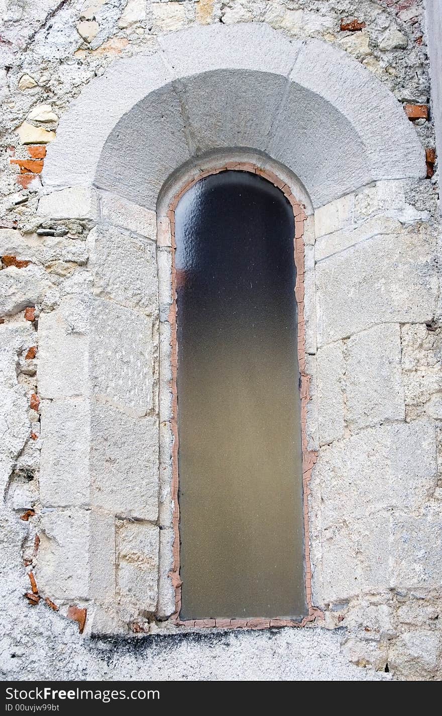 Narrow castle window with glass.