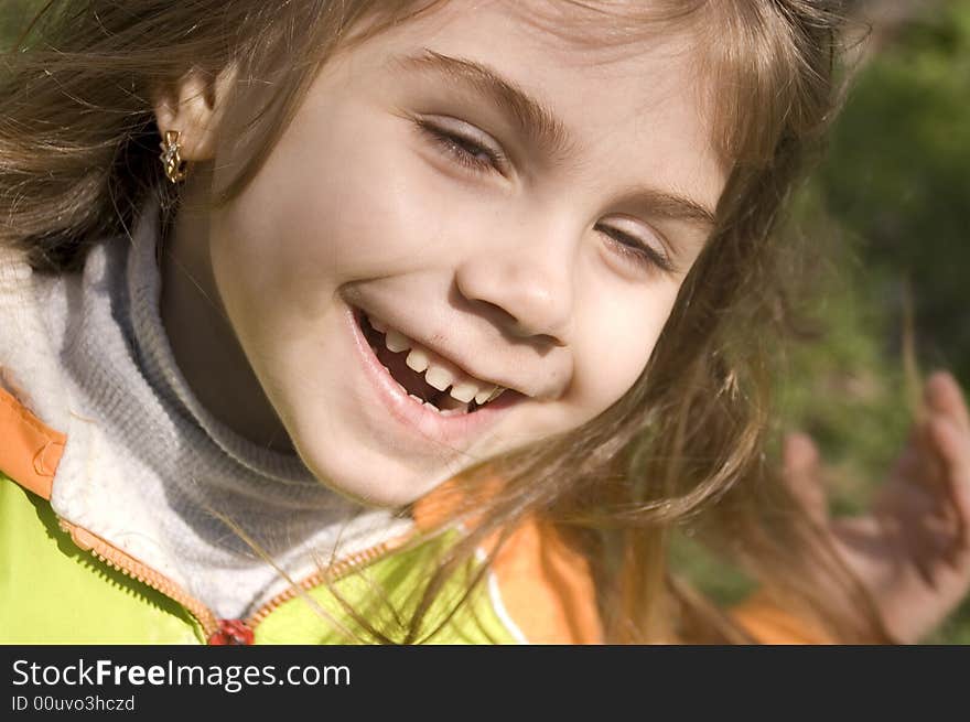 Happy laughing little girl outdoors in the sunlight. Happy laughing little girl outdoors in the sunlight