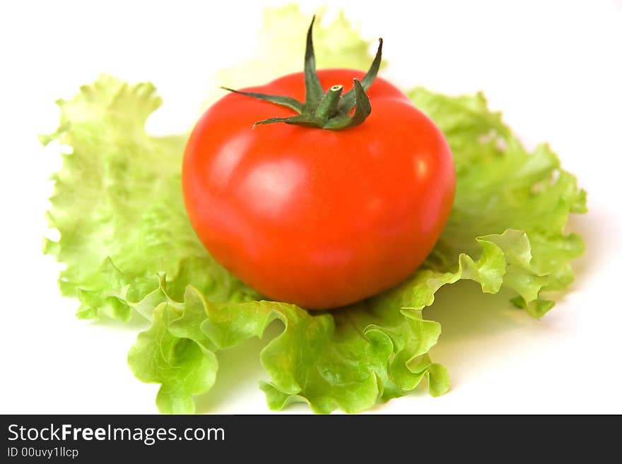 A tomato on a list of a salad. A tomato on a list of a salad