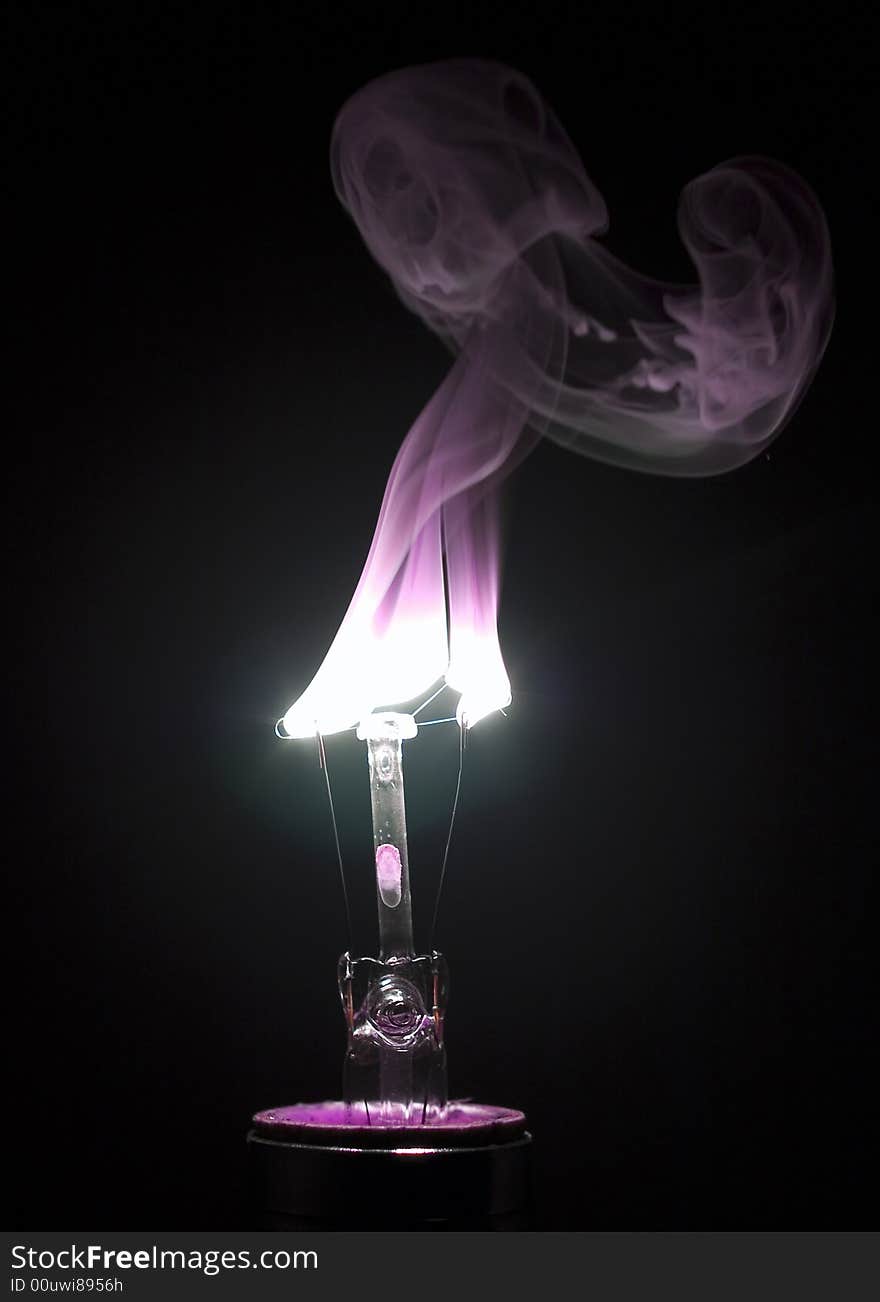 Burning light bulb with a purple hue. Burning light bulb with a purple hue