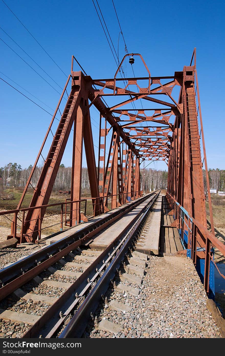 Rail tracks on the bridge, forest on the other river bank. Rail tracks on the bridge, forest on the other river bank