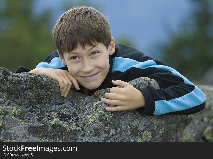 Boy looking from behind the stone