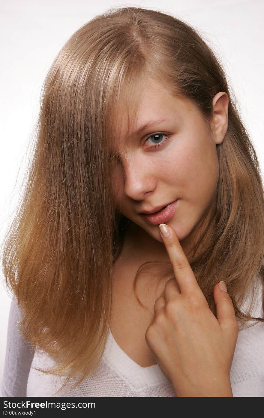 Portrait of a young blond girl with finger at her lips. Portrait of a young blond girl with finger at her lips