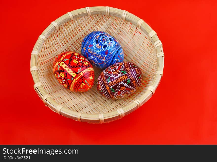 Three russian tradition easter eggs side be side in yellow basket over red. Three russian tradition easter eggs side be side in yellow basket over red