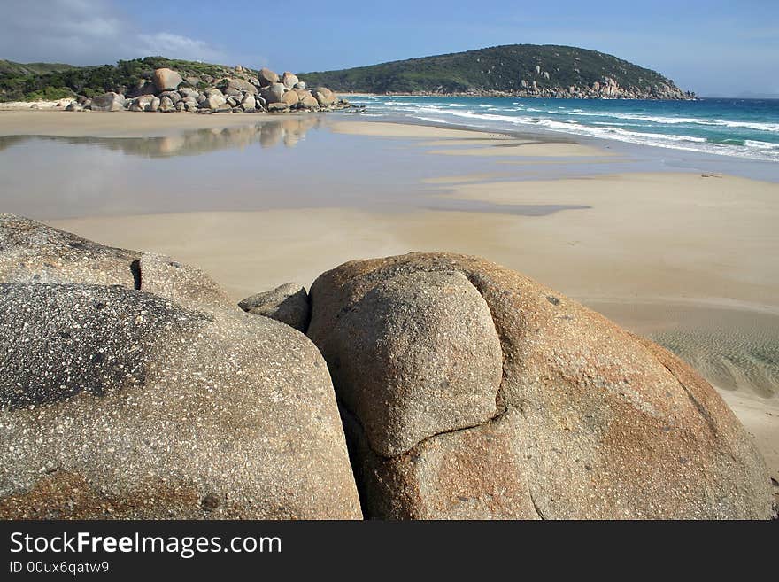 Sandy beach against huge stones