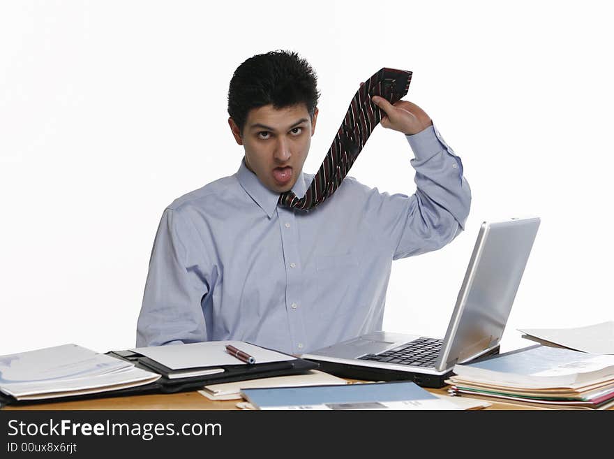 Fed up business man working at his laptop. Isolated against a white background. Fed up business man working at his laptop. Isolated against a white background