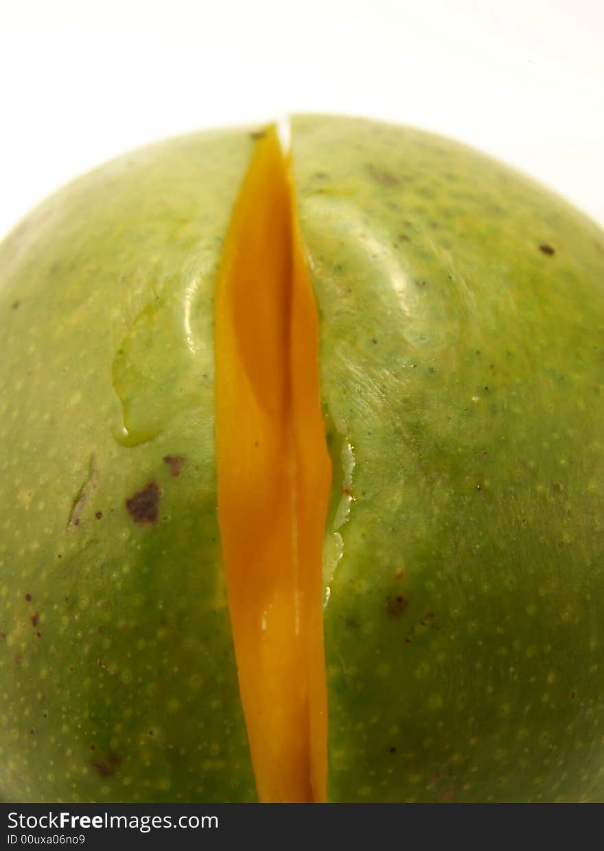 Close up image of a bright green mango with a small slice removed. Close up image of a bright green mango with a small slice removed.