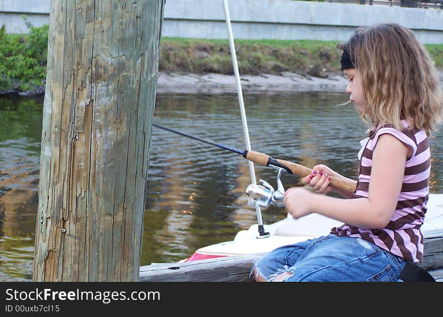 Little girl fishing off dock