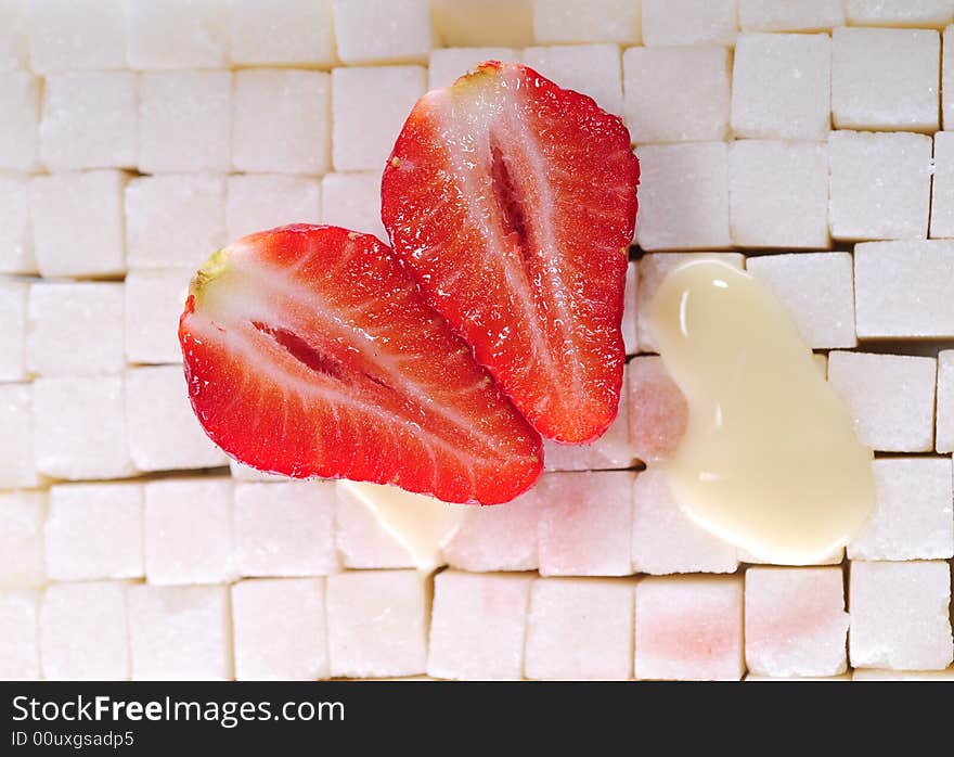 White sugar cubes background with strawberry and milk. White sugar cubes background with strawberry and milk