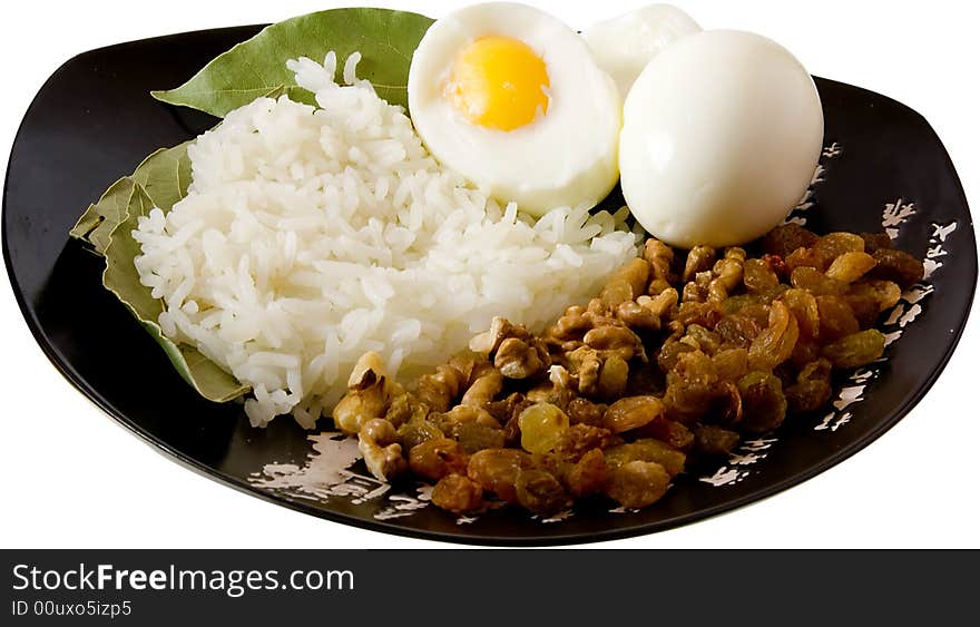 Rice, eggs, nuts and raisin on the isolated plate with hieroglyphes. Rice, eggs, nuts and raisin on the isolated plate with hieroglyphes