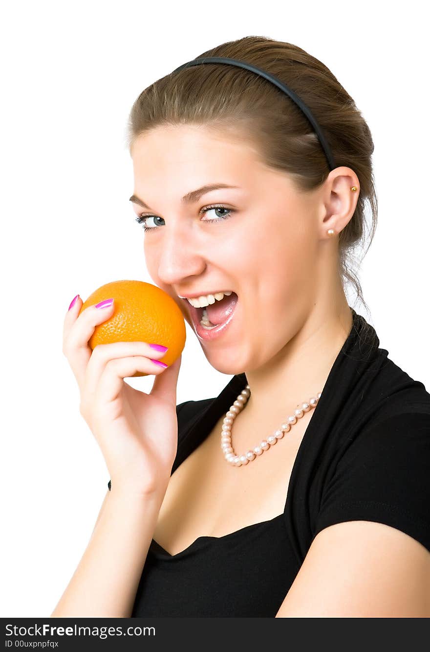 Beautiful girl in a black evening dress bites an orange isolated on a white background. Beautiful girl in a black evening dress bites an orange isolated on a white background