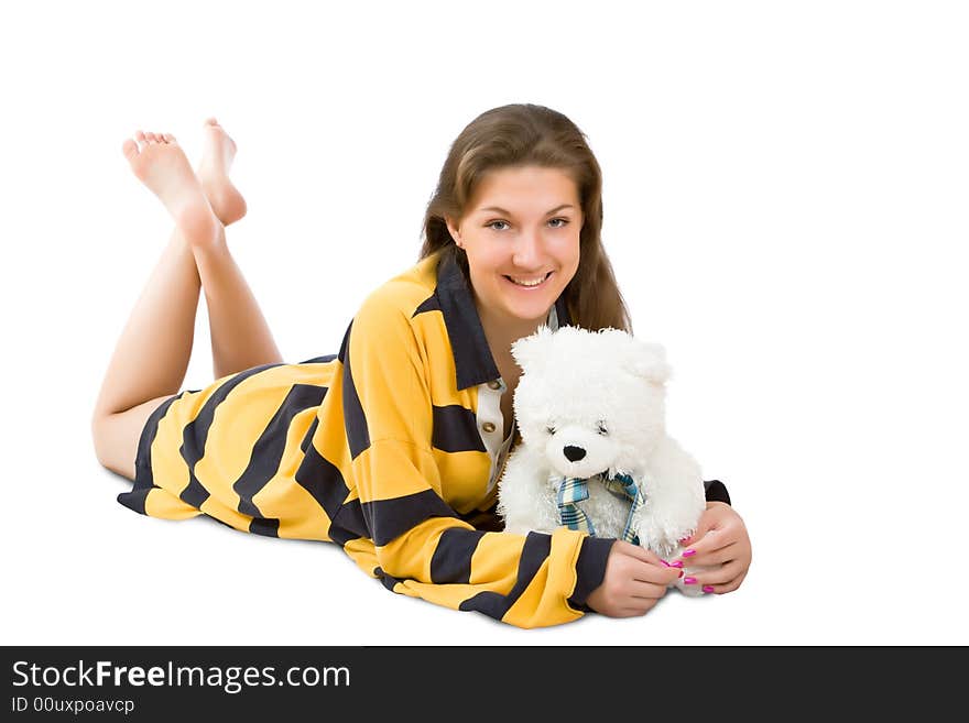 Attractive girl lays and embraces a toy bear isolated on a white background