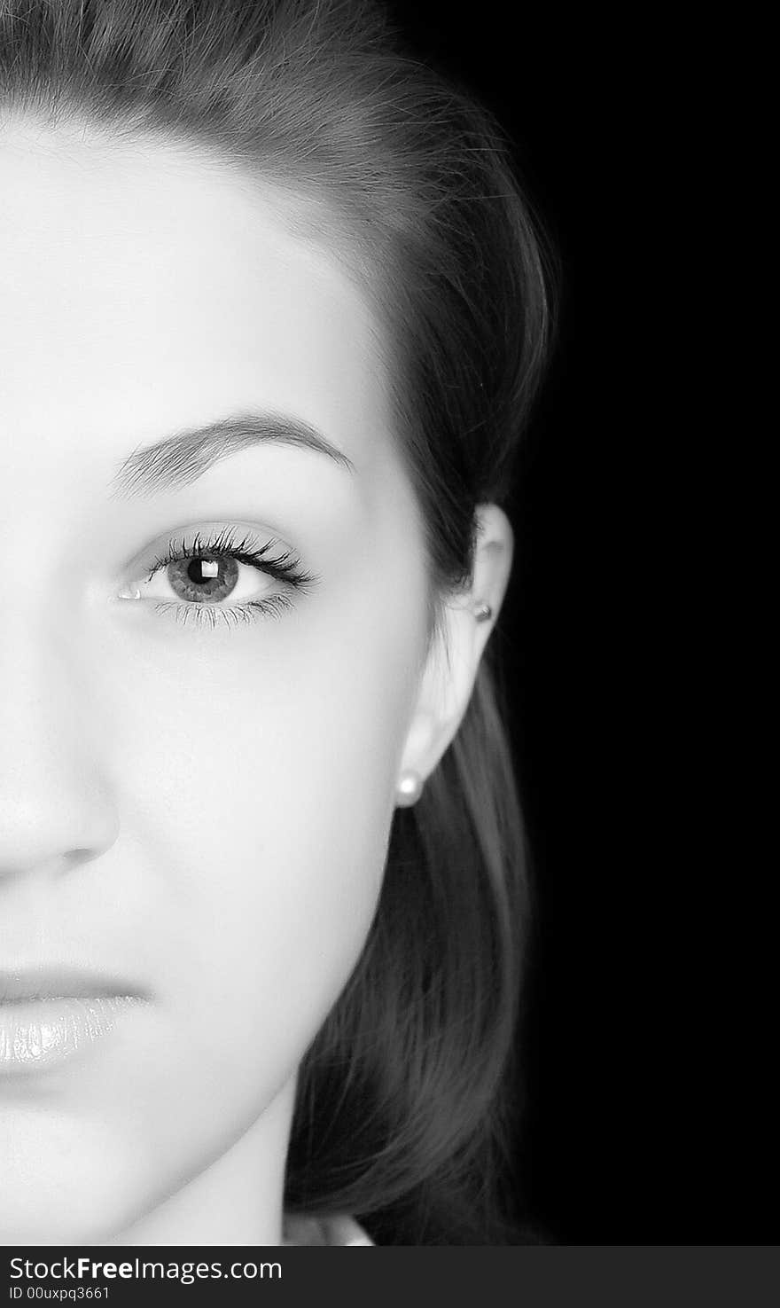 Half of face of the beautiful girl black-and-white isolated on black