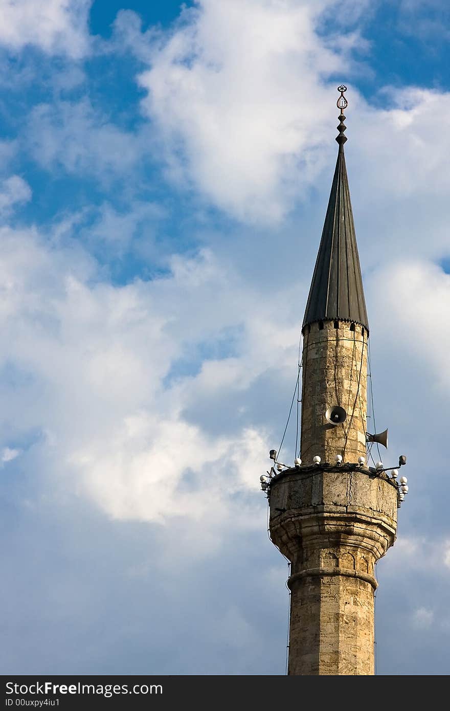 Single mosque minaret under the blue and cloudy sky