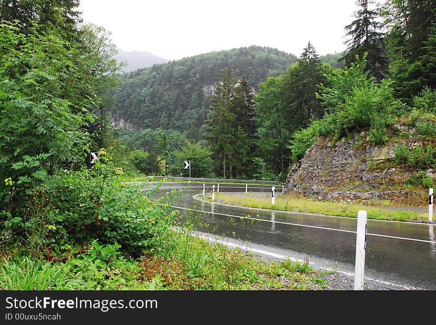 Winding road in mountain, blind bend，after rain, the road was wet。