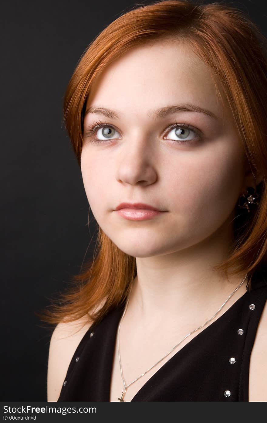 The charming young girl in studio on black background