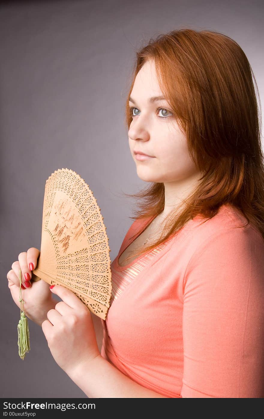 The charming young girl in studio on black background