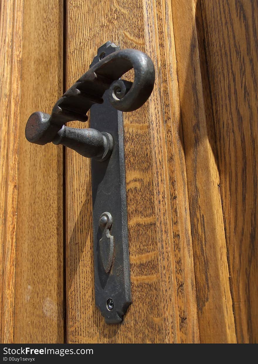 Antique door handle on the old wooden door. Antique door handle on the old wooden door