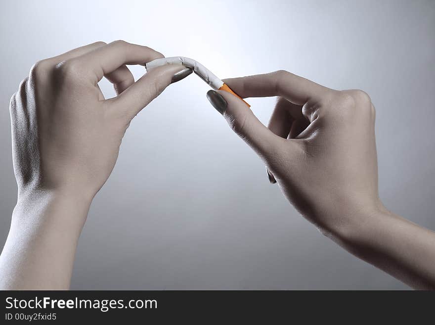 A female hands are breaking the cigarette