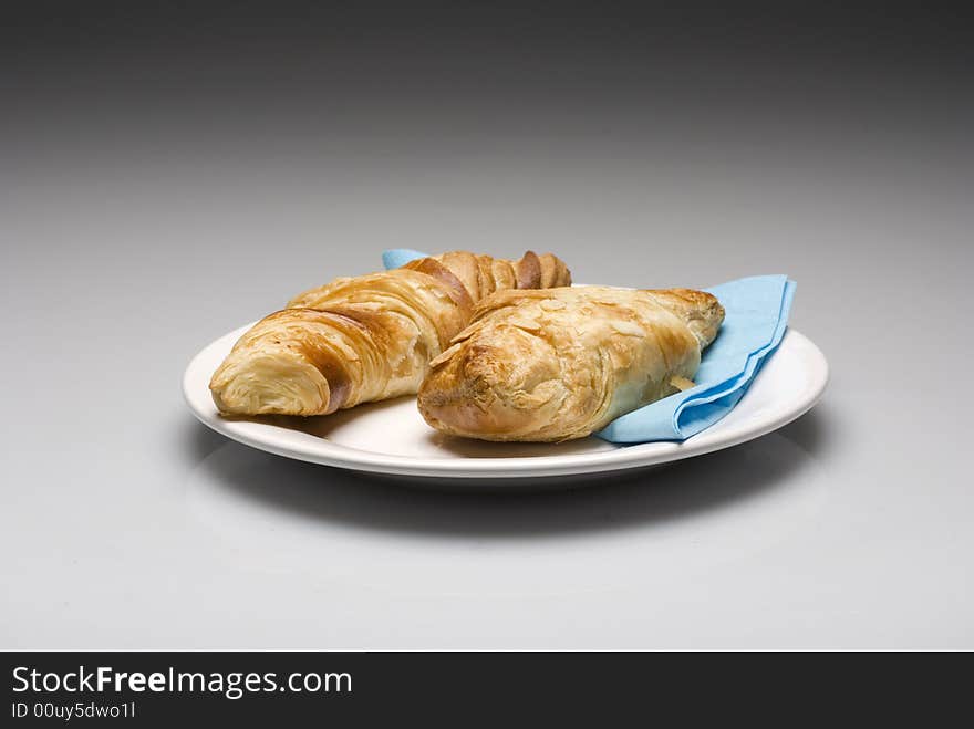 Croissants on a plate with a blue tissue