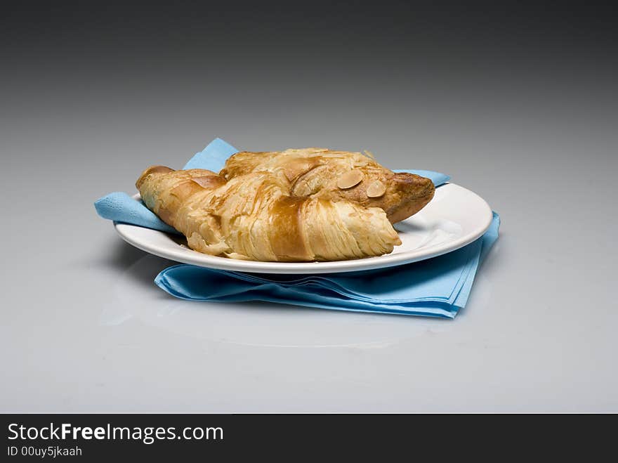 Croissants on a plate with a blue tissue