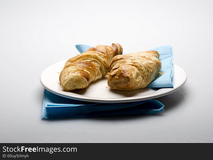 Croissants on a plate with a blue tissue