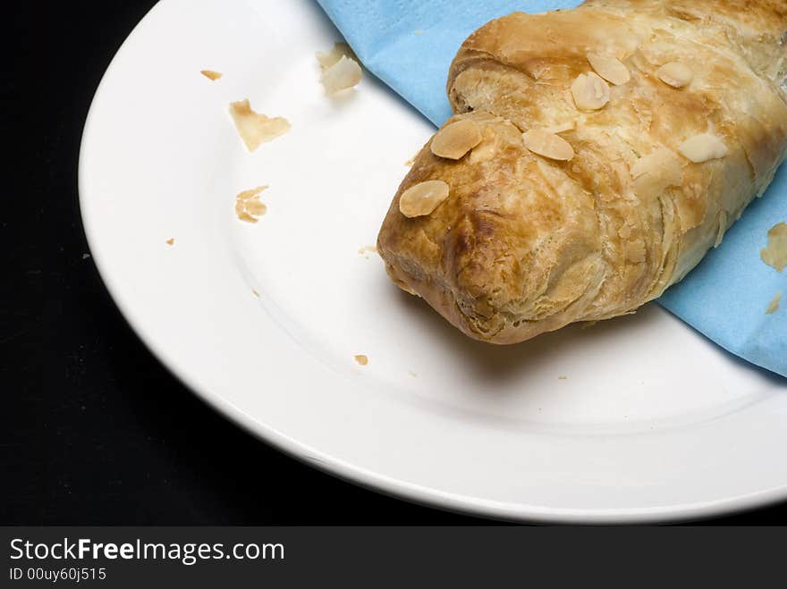 Croissants on a plate with a blue tissue isolated on black background