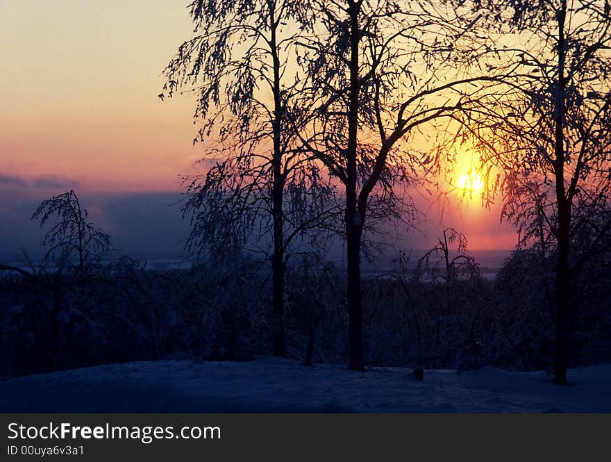 The sun sets on a frozen field. The sun sets on a frozen field