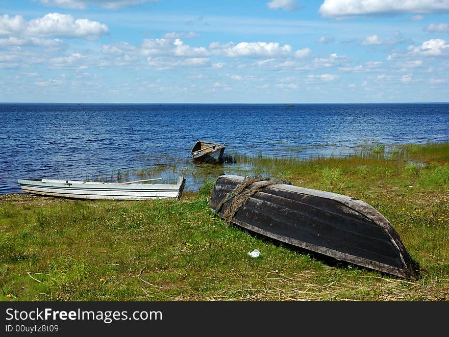 Three old fishing wooden boats on the lake bank in north Russia. Three old fishing wooden boats on the lake bank in north Russia