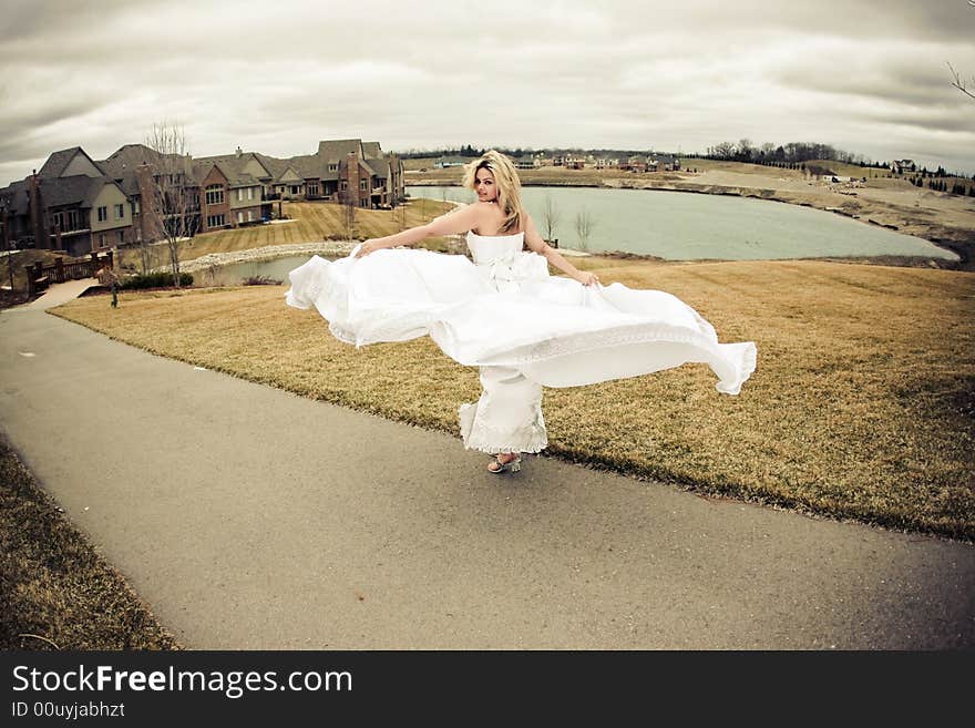 Runaway bride in the field during a stormy windy day. Runaway bride in the field during a stormy windy day