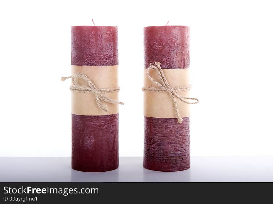 Red Christmas Candles tied with string on a white table against a white background. Red Christmas Candles tied with string on a white table against a white background