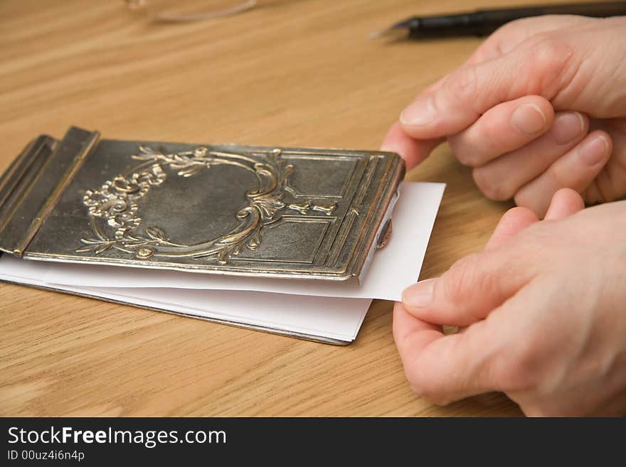 Drawing a paper from silver notebook cover for writing a note