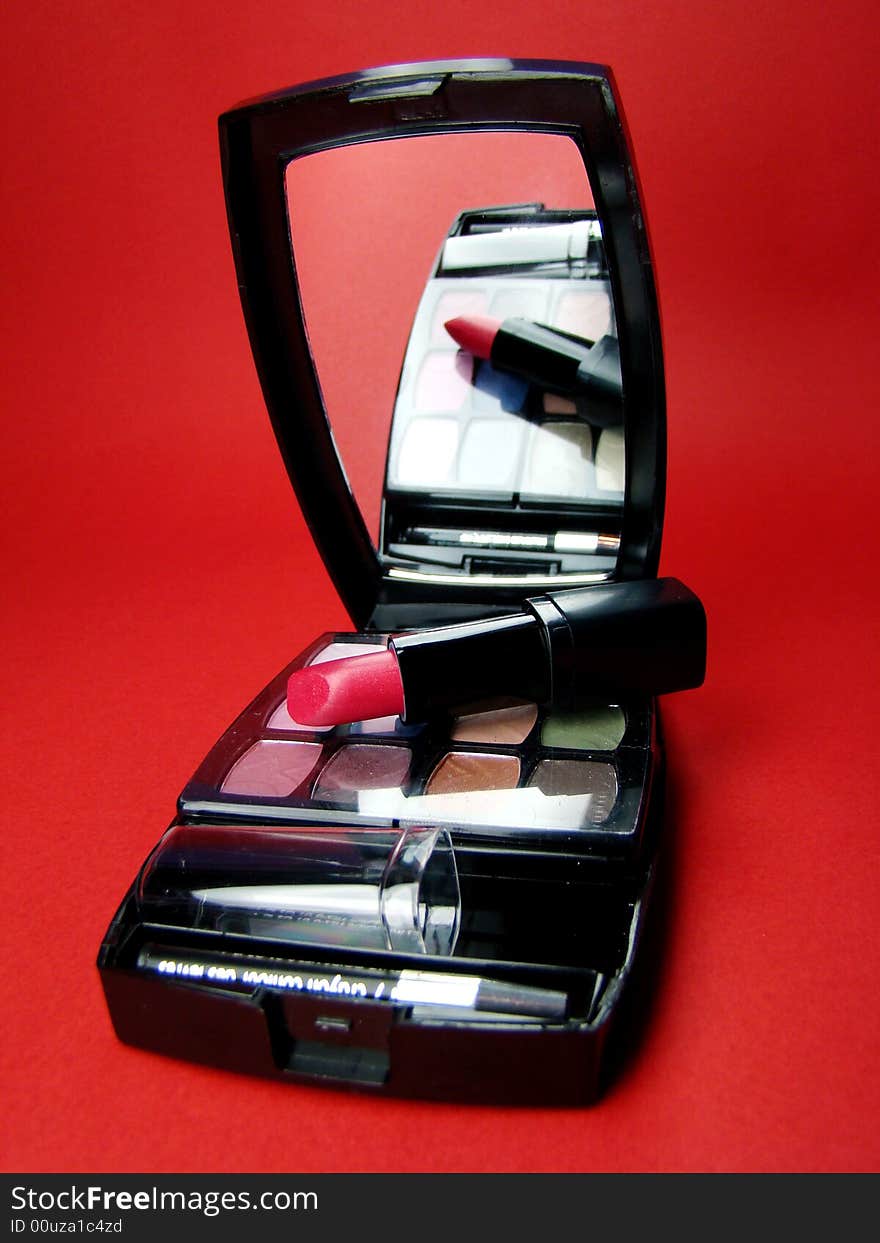 Red lipstick over opened makeup kit. Red lipstick over opened makeup kit