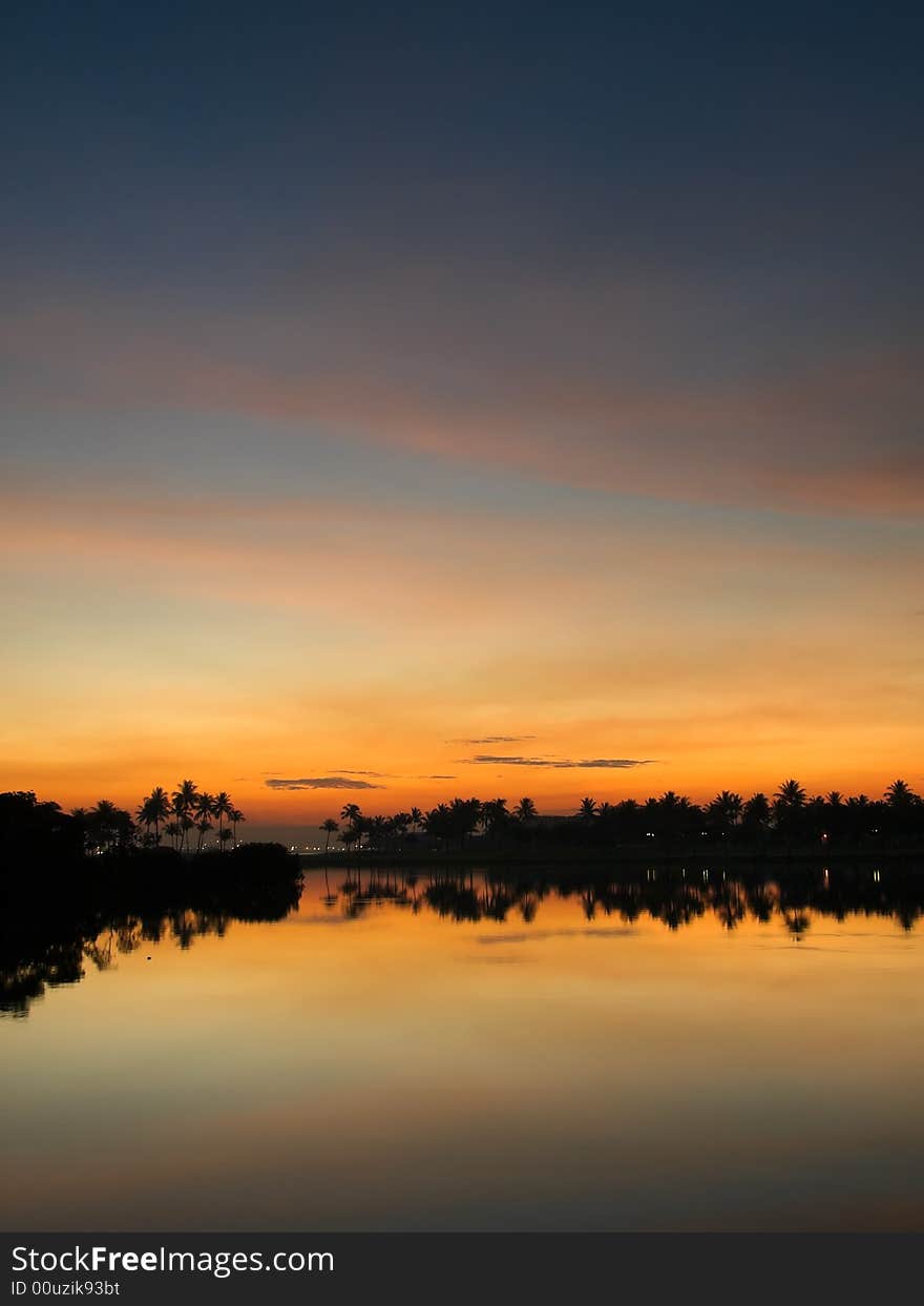 Tropical Holiday Island Resort at sunset reflected over a lake at a golf course. Tropical Holiday Island Resort at sunset reflected over a lake at a golf course