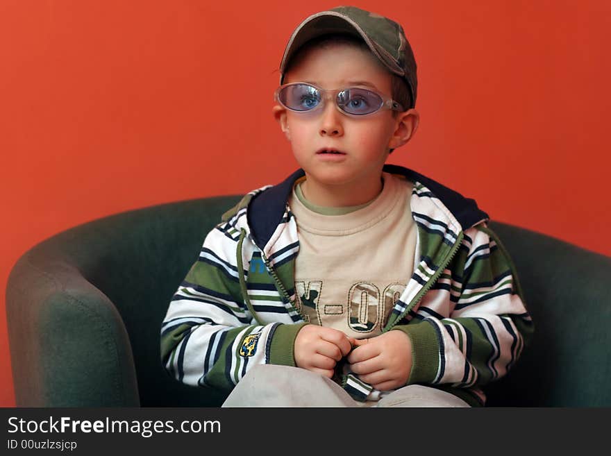 A suprised boy sitting on the armchair