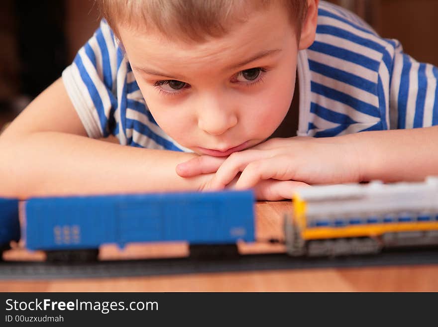 Boy looks at toy railroad