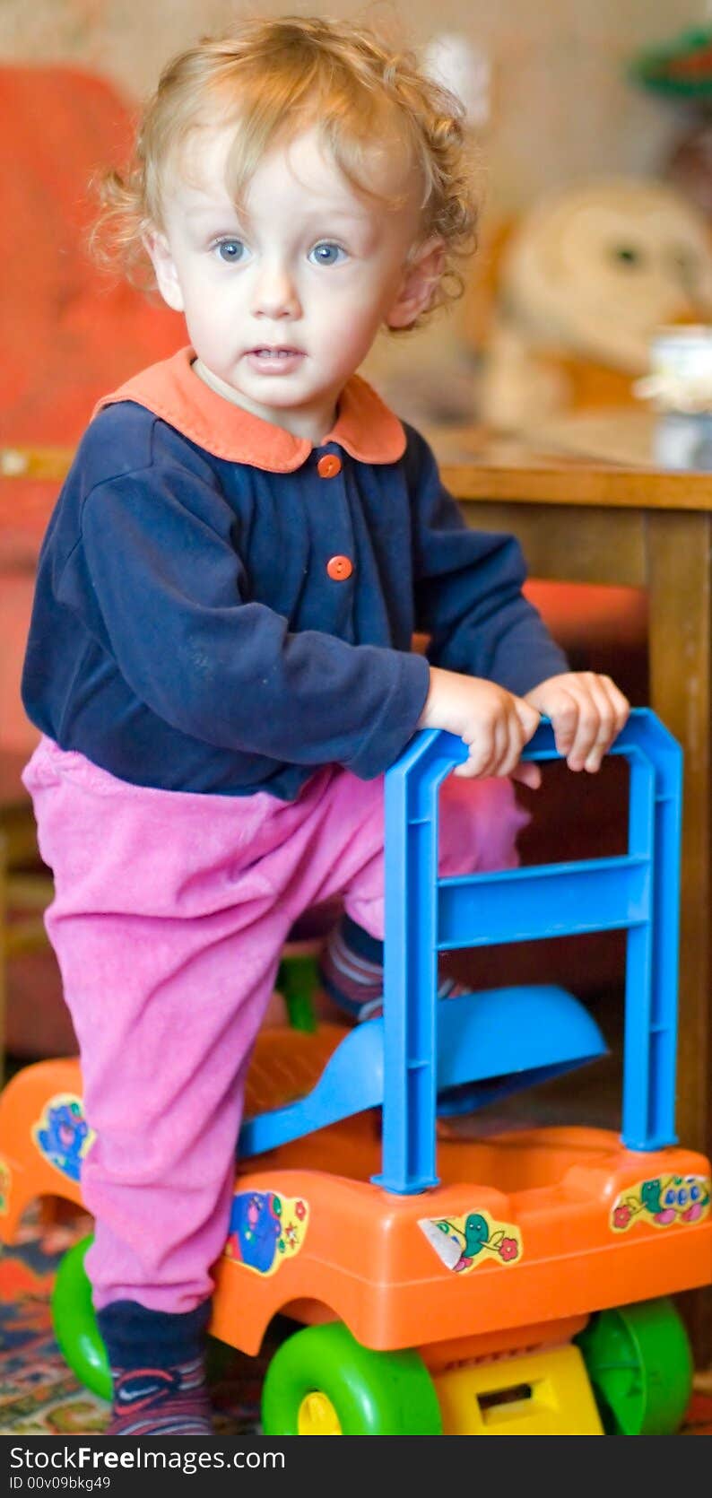 Small curly boy rises from the orange machine