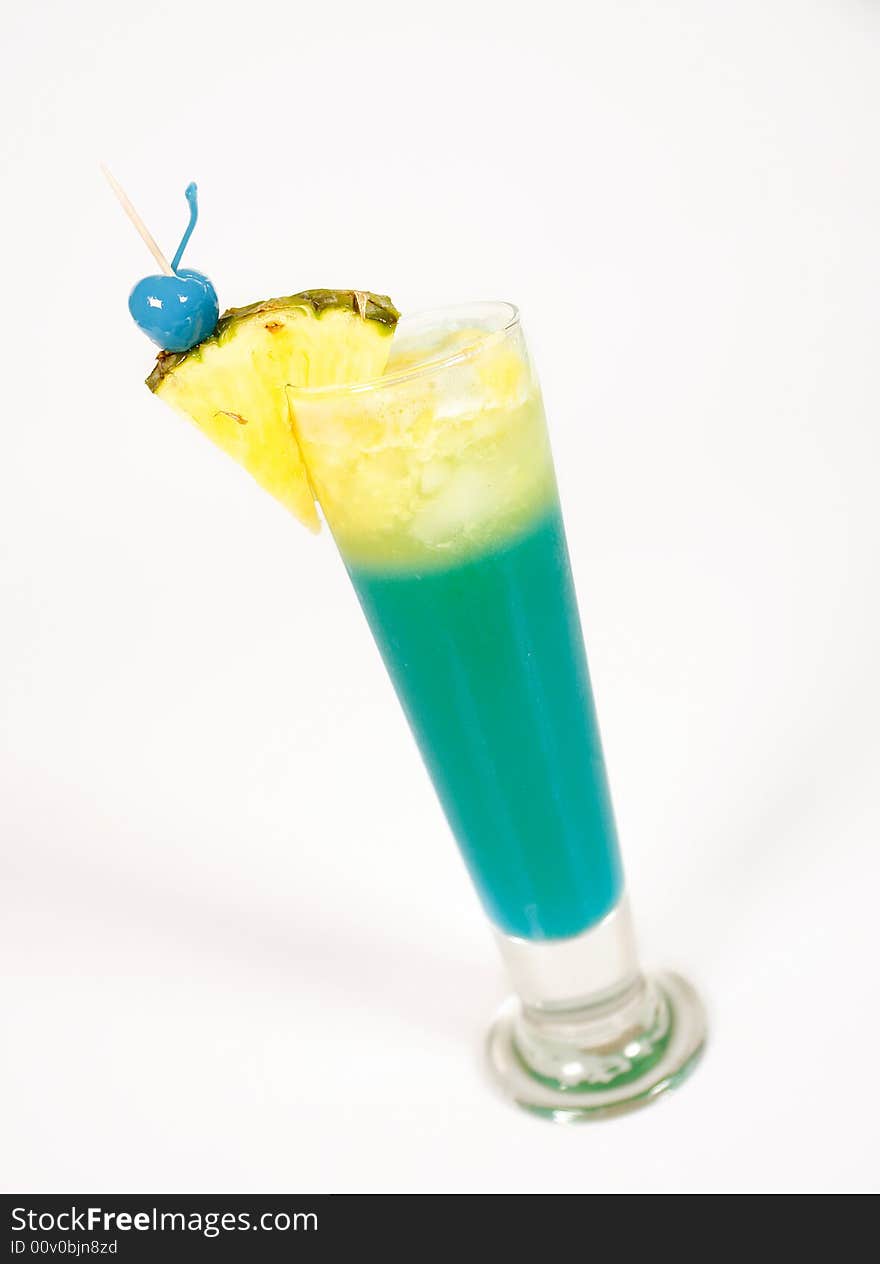 Green cocktail with pineapple and blue cherry