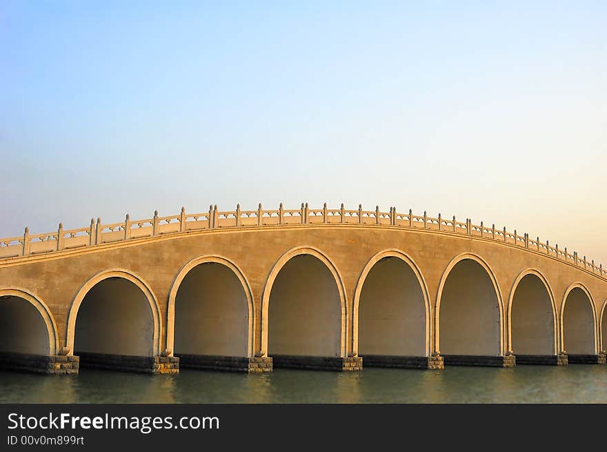 Stone arch bridge at sunset time