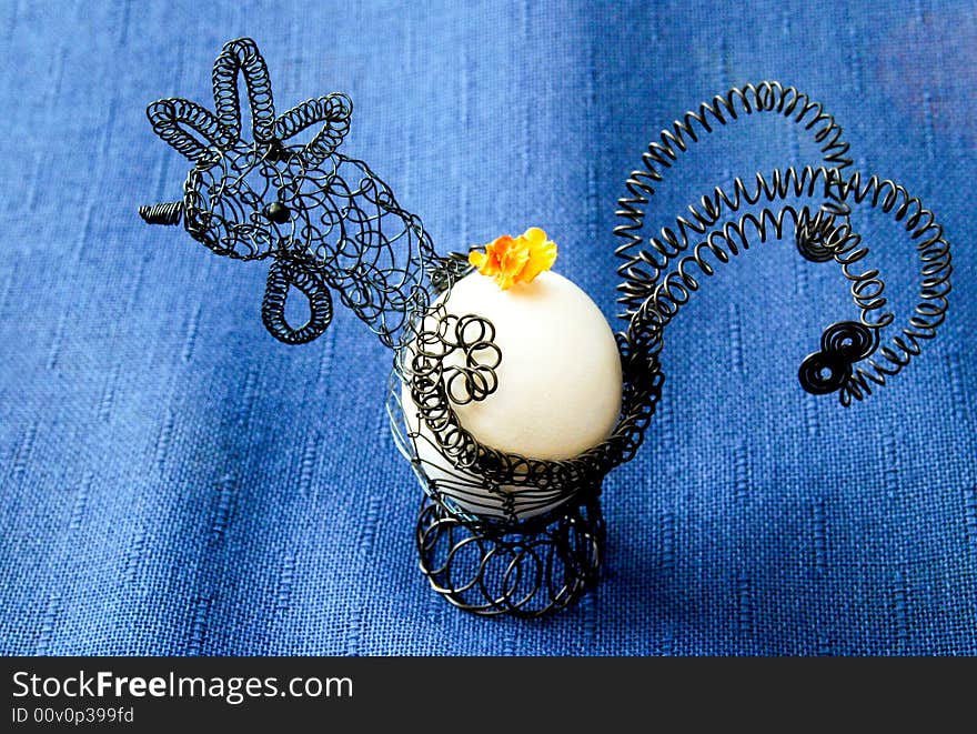 Wire hen on a blue tablecloth. Wire hen on a blue tablecloth