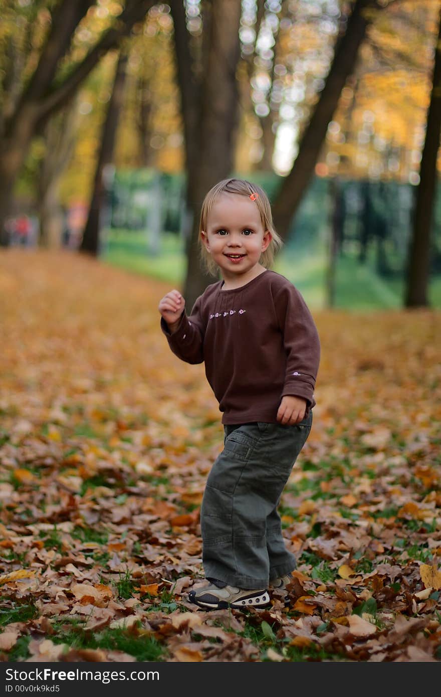 Little beauty girl in the autumn park