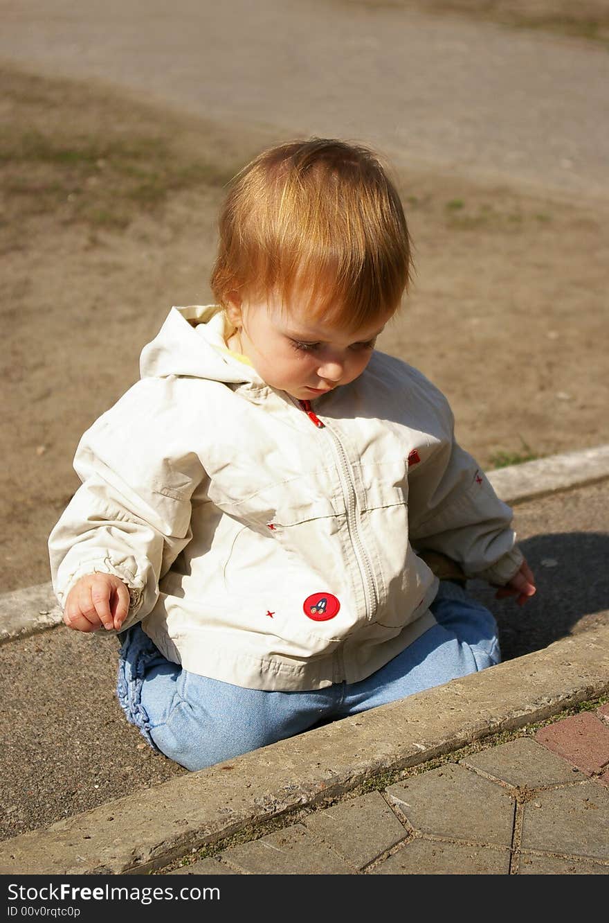 Little girl plays on the street