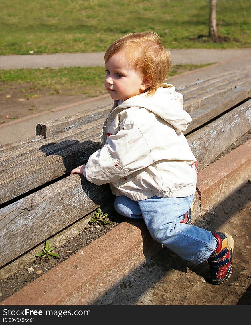 Small girl sits on the bench on the neglected stadium. Small girl sits on the bench on the neglected stadium