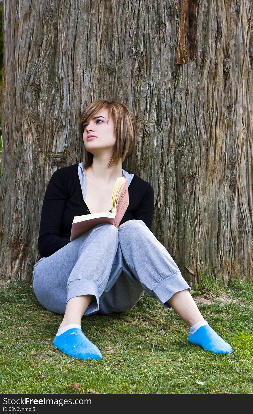 Young woman reading a book in the park